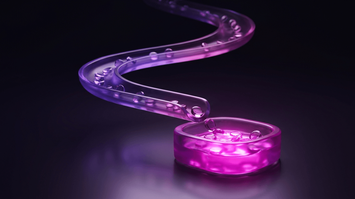 Small glass tokens travelling a lit track and collecting in a bright basin
