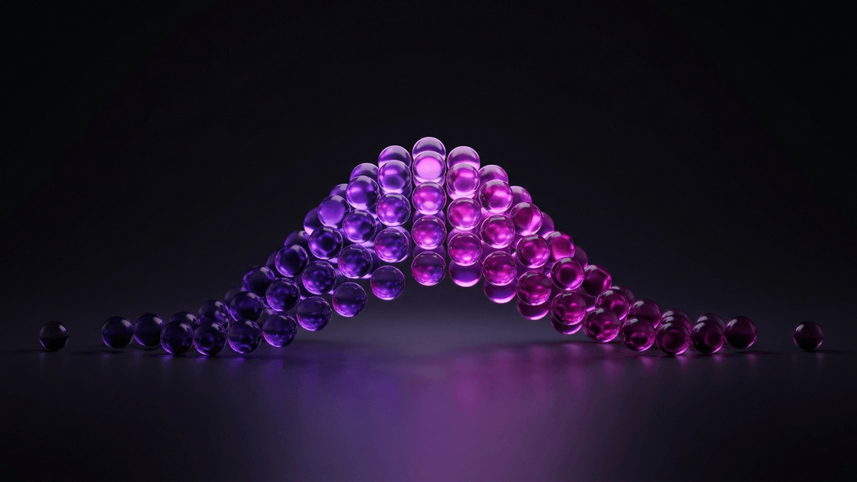 A bell-shaped drift of glass spheres, brightest through its wide middle band
